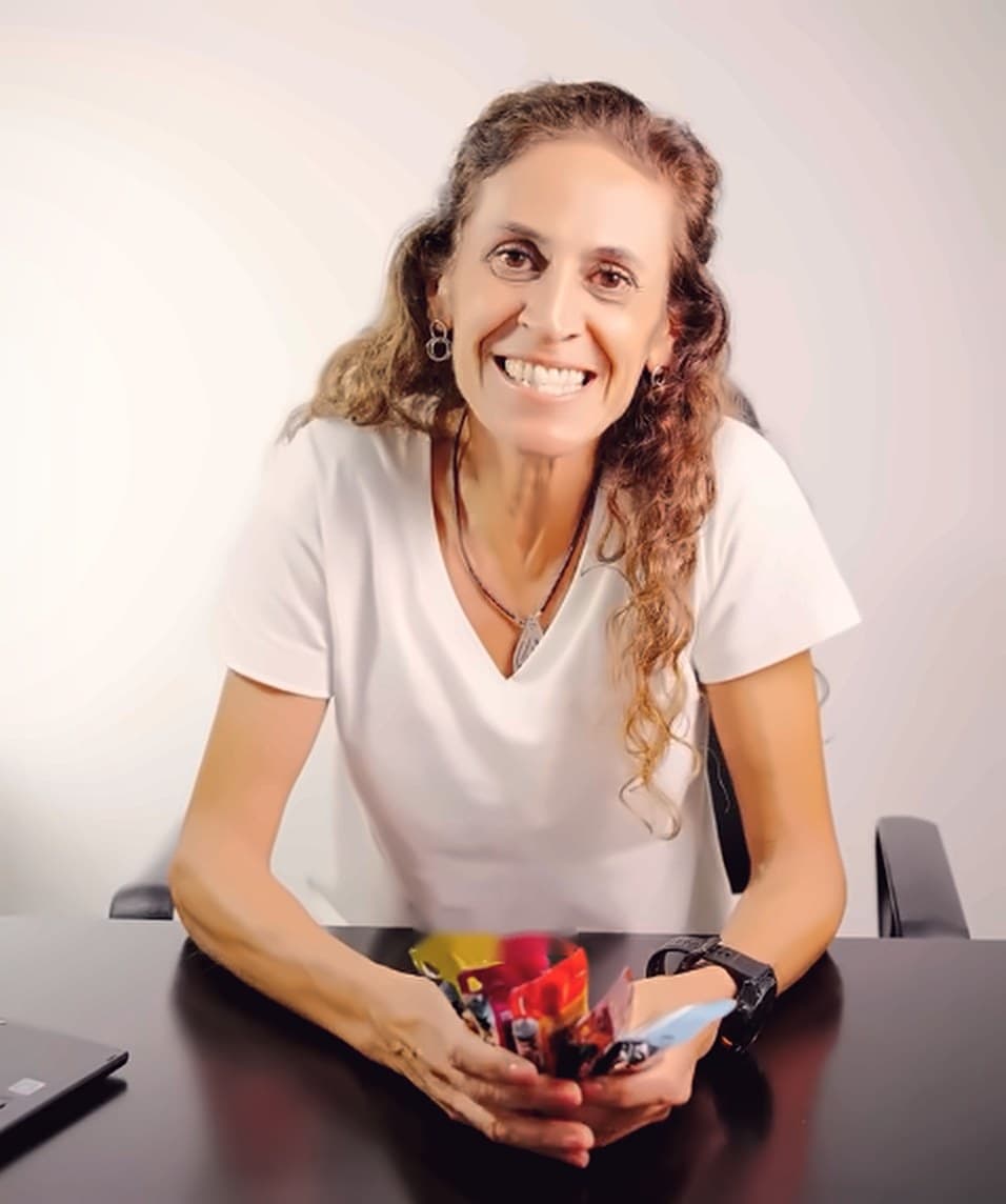 Ivana Lencina, licenciada en nutrición, sonriendo en su consultorio con geles y suplementos deportivos